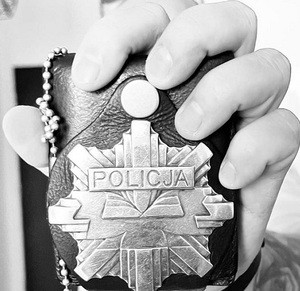 Dłoń trzymająca odznakę policyjną
