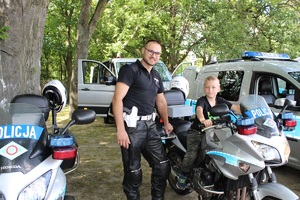 Policjant z chłopcem obok służbowego motocykla