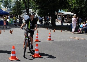 Chłopiec na rowerze w miasteczku ruchu drogowego, jedzie miedzy pachołkami