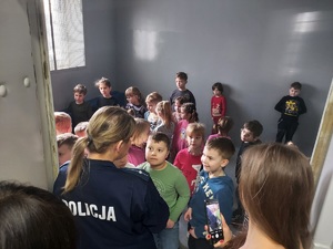Dzieci oglądają jedno z pomieszczeń dla osób zatrzymanych.