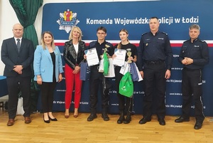 Zdjęcie Alana Wiśniewskiego oraz dziewczyny która zdobyła tytuł najlepszej zawodniczki, obok stoją zaproszeni goście i policjanci.