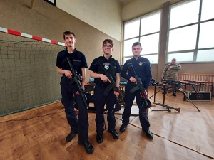 Trzech chłopców z klasy mundurowej, pozują do zdjęcia z bronią